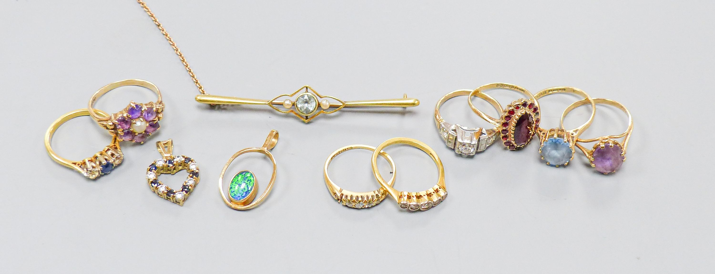 Three 18ct gold and gem set rings including two five stone half hoop(one stone missing) and a sapphire and diamond three stone, gross weight 7.3 grams, four 9ct and gem set rings and a 9ct pendant, gross 11.8 grams, a 15